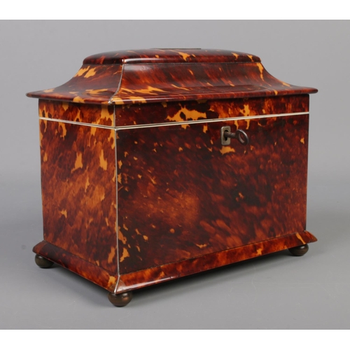 78 - A 19th century tortoise shell tea caddy raised on four bun feet. Having silvered banding and monogra... 