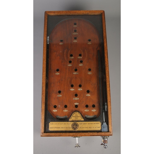 85 - An early 20th century bagatelle game, The Advance Pin Table. With oak case and glazed top, being coi... 