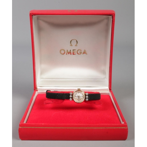 99 - A ladies gold and six stone diamond Omega manual wristwatch.