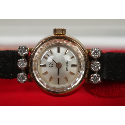 99 - A ladies gold and six stone diamond Omega manual wristwatch.