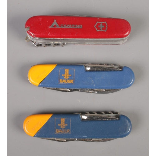 256 - Three multi-tools including Swiss camping and Bauer examples.