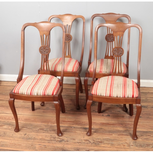 570 - A set of four mahogany chairs with upholstered seats and carved back detail.