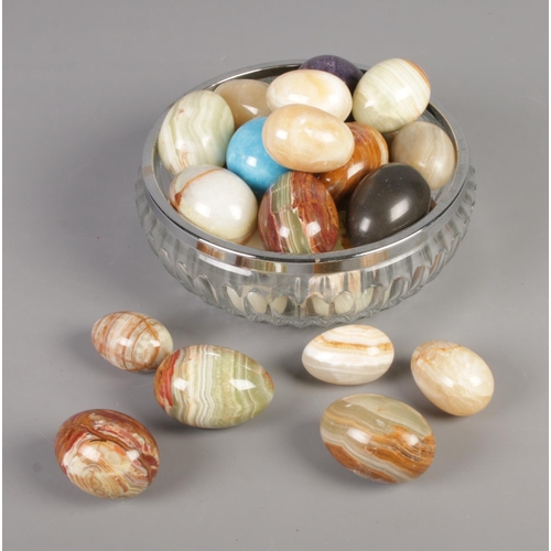 264 - A cut glass bowl and box containing an assortment of hardstone eggs. Approx. 26 eggs.