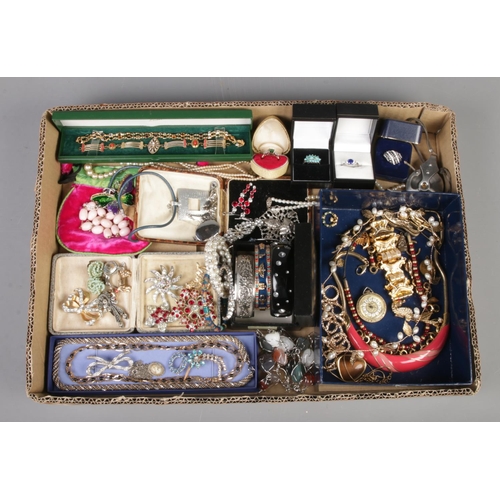 185 - A tray of costume jewellery. Includes paste set brooches, sapphire 'sample' ring, bangles, bracelet ... 