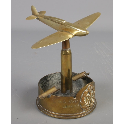 250 - A RAF brass trench art ashtray. Formed as a war plane at the top of a bullet. Baring broad arrow mar... 