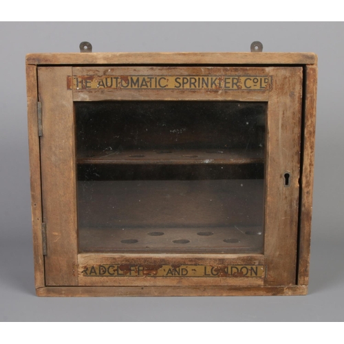 287 - A wall mounted wooden display case advertising 'The Automatic Sprinkler Co Ltd'. 28cm tall.