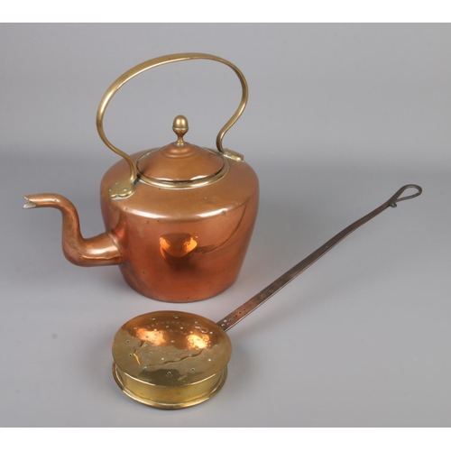 301 - A copper and brass kettle along with a brass and iron roasting pan.