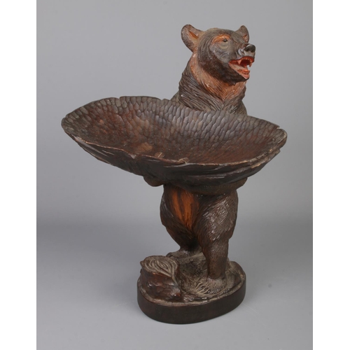 305 - A black forest style carved bear holding dish. Approx. height 39cm.