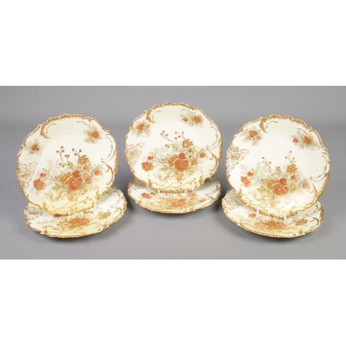 309 - A set of six Limoges dessert plates with floral and gilt decoration.