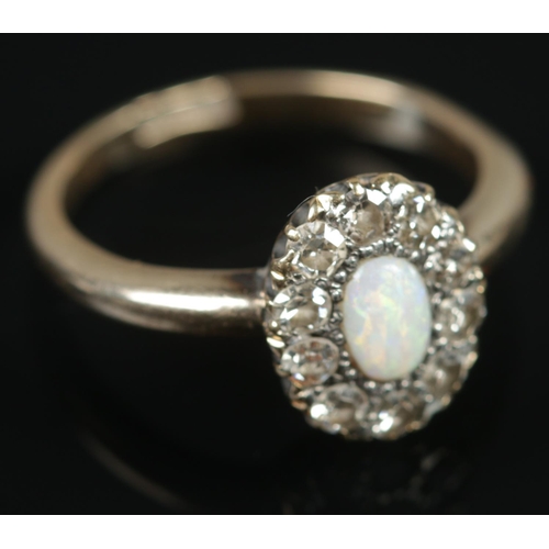 485 - An 18ct gold opal and diamond ring. Central opal surrounded by ten diamonds. Size N, 3.68g.