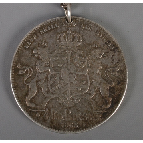 495 - A Swedish 1868 silver coin on chain. 'Carl XV Sveriges Norr. Goth. Och Vend. Konung' to one side and... 