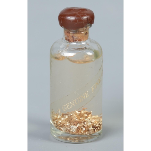 501 - A sealed bottle labelled '24ct genuine fine gold'. 6cm