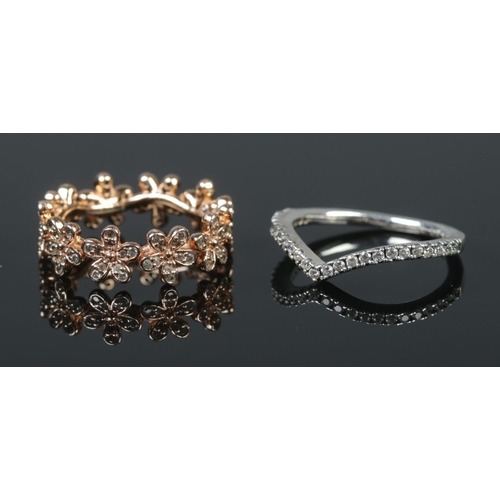 510 - Two Pandora rings. Includes silver wishbone ring (Size J 1/2) and gilt floral example (Size I).