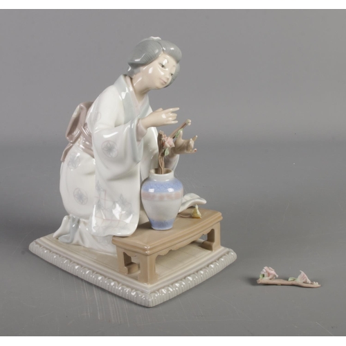 236 - Lladro figurine of a kneeling lady tending to flowers (damaged flowers)