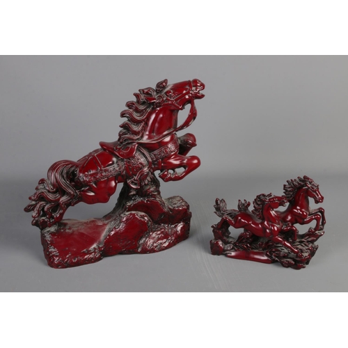 248 - Two red resin figurines of oriental galloping horses. Largest is approx 32cm high.