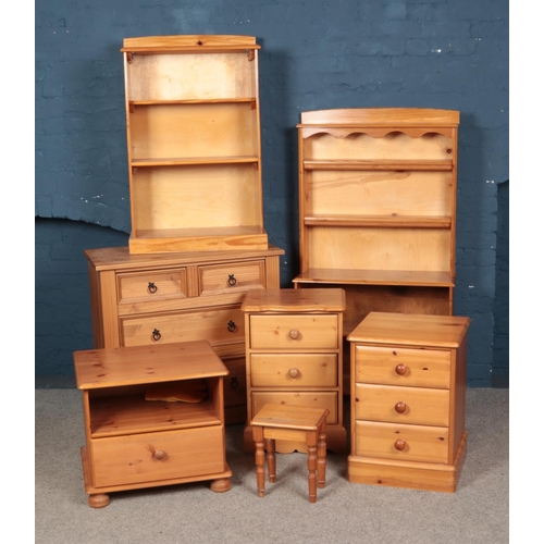 537 - A large mix of pine furniture including corona drawers, bedside tables and bookcases.