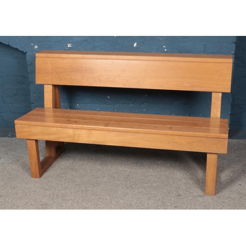 549 - An oak paneled bench. Approx. dimensions 141cm x 83cm x 51cm.