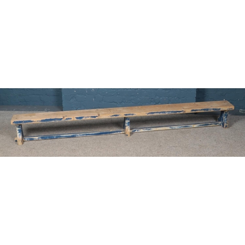 551 - A pine bench with painted legs. Approx. dimensions 239cm x 28cm x 19cm.