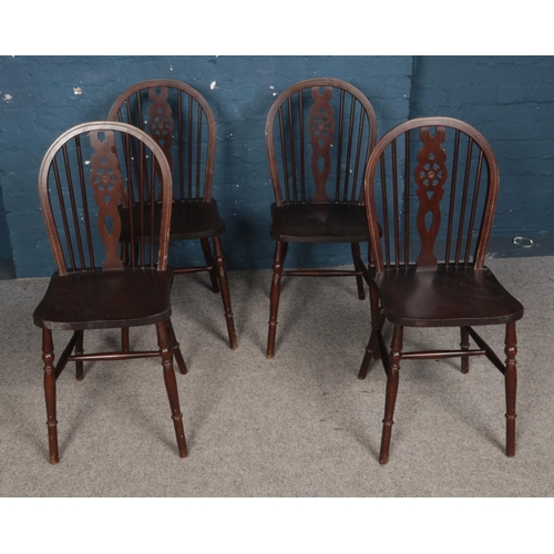 556 - A set of four wheelback dining chairs.