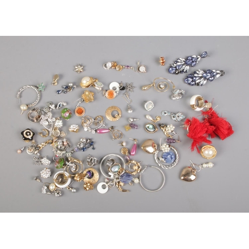 106 - Over 60 pairs of costume jewellery earrings including tassels, snowflake and clip-on examples.