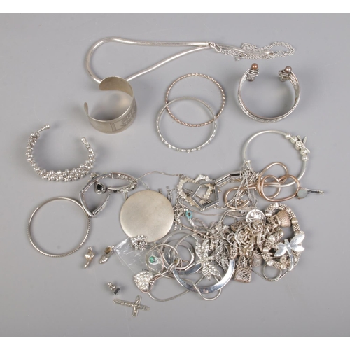 108 - A collection of white metal costume jewellery including bangles, bracelets, novelty charms, etc.