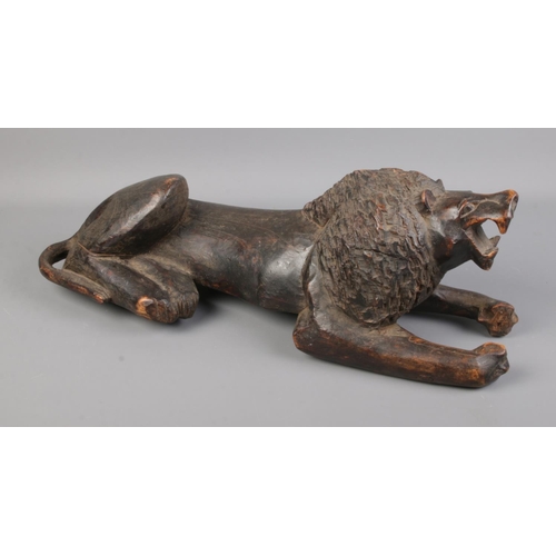 127 - Tribal hand carved lion in recumbent pose.

54cm long