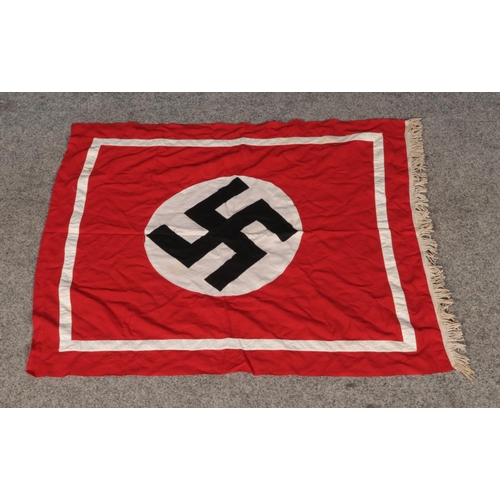 14 - A vintage cotton flag bearing swastika emblem and decorative fringe to one side. Approx. dimensions ... 