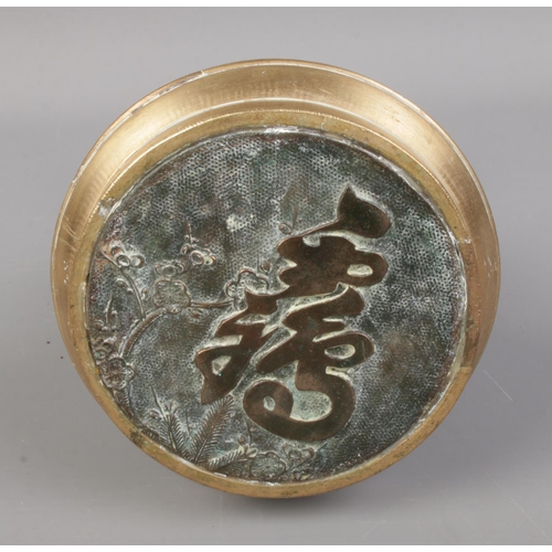 148 - A Chinese brass seal featuring elephant head handles and floral decoration.