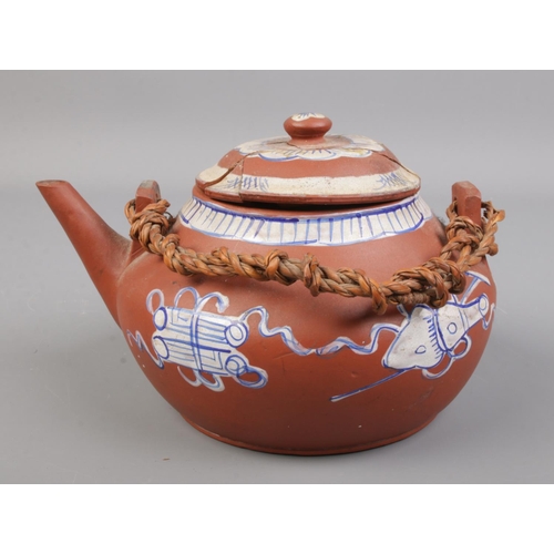 155 - A Chinese Yixing teapot decorated in blue and white. Height 11cm, Length 19cm.