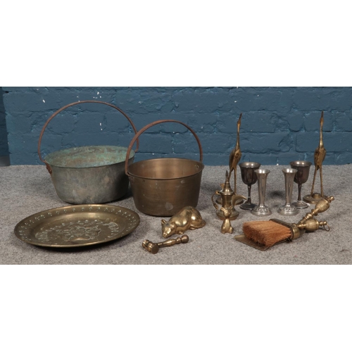 185 - A good collection of metalwares, to include two jam pans, stork ornaments and goblets.