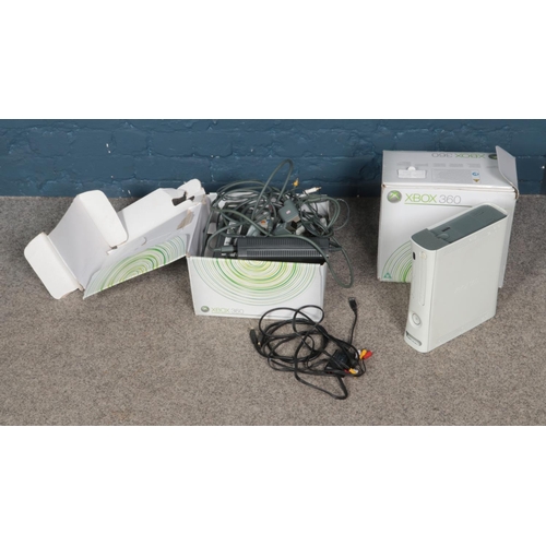 219 - Two boxed Xbox 360 games consoles and accessories.