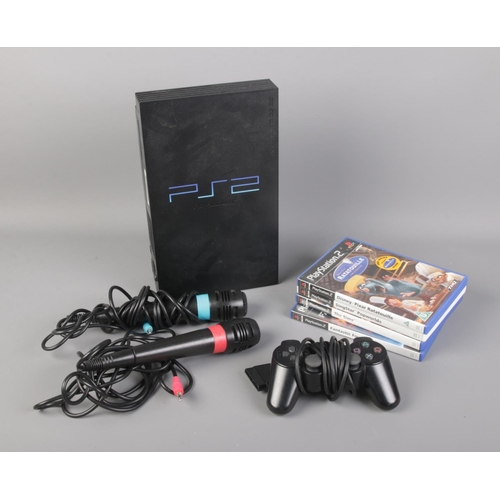 220 - A Playstation 2 games console with controller, accessories and small selection of games.