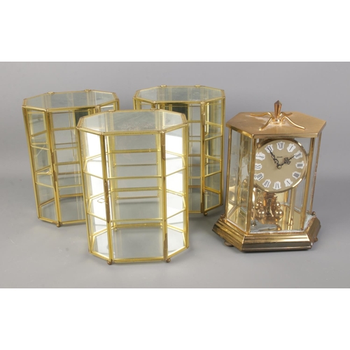 227 - A Kundo mantel clock along with three small glass display cabinets.