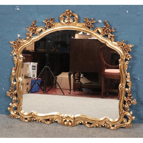 289 - A large ornate gilt framed mirror, with curved top. Height: 107cm, Width: 117cm.