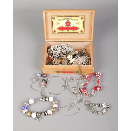 87 - A box containing an assortment of charm bracelets and necklaces including small quantity of silver c... 