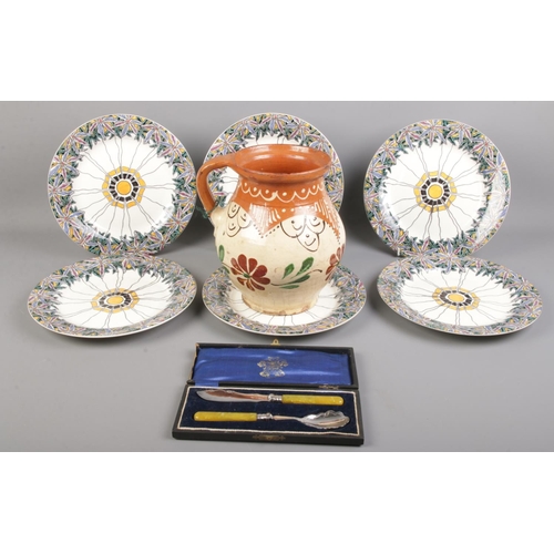 88 - Six Wedgwood Etruria cabinet plates along with a pottery jug and a cased silver plated cutlery set.