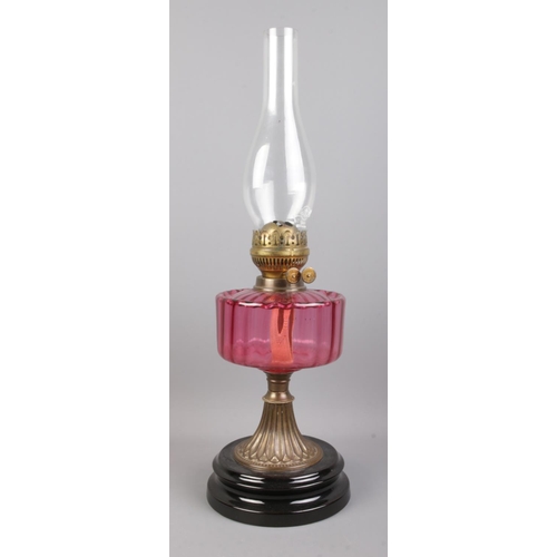 92 - A Flash of Slough flamingo glass and brass oil lamp, on stepped circular base.