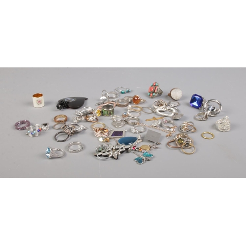 96 - A quantity of costume jewellery rings and pendants including  floral, dragonfly and heart examples.