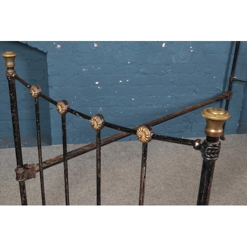 511 - A cast iron and brass single bed on castors