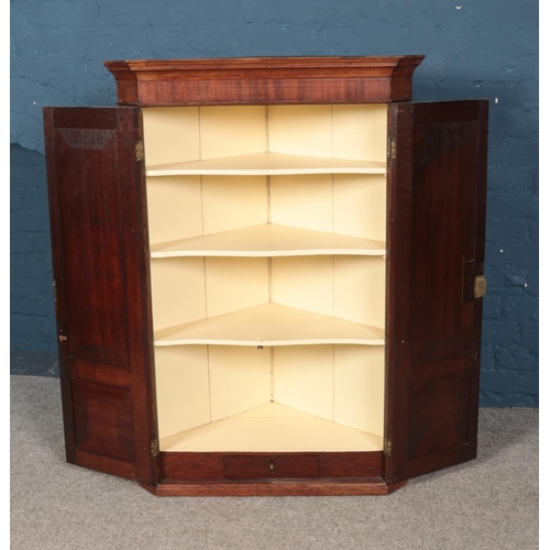 512 - A Georgian mahogany corner cupboard with painted interior. Approx. dimensions 84cm x 122cm x 46.5cm.