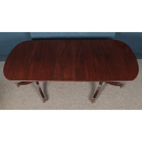 516 - A 20th century Regency style mahogany twin pedestal dining table, on turned columns with tripod spla... 