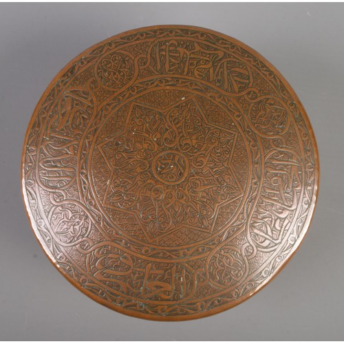 26 - An Eastern circular copper box with extensive engraved decoration. Height 7.5cm, Diameter 12cm.