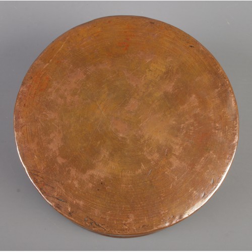 26 - An Eastern circular copper box with extensive engraved decoration. Height 7.5cm, Diameter 12cm.
