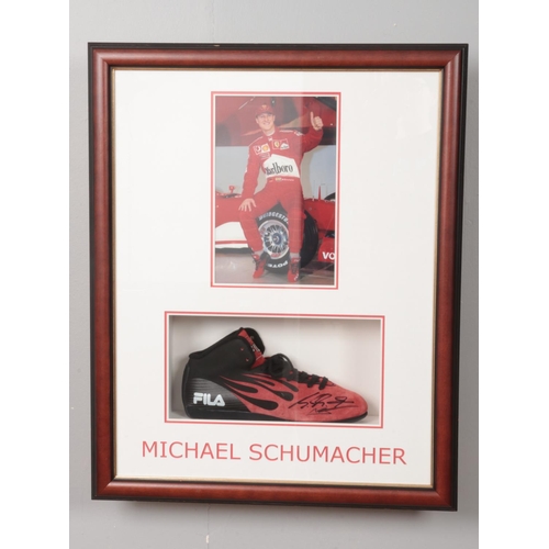 250 - A signed Michael Schumacher right Fila shoe mounted in display case along with photograph. Approx. c... 