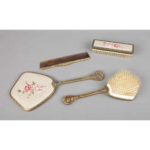 108 - A vintage vanity set featuring floral petit point embroidery. Includes brushes, comb and mirror.