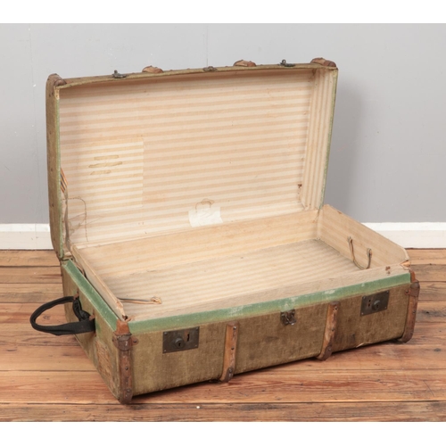 231 - A wooden bound canvas trunk, displaying several luggage stickers and with hinged opening and fitted ... 