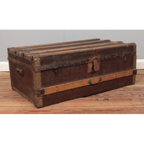 232 - A wooden bound hinged top trunk, with tin base. Height: 32cm Depth: 47cm Width: 83cm.