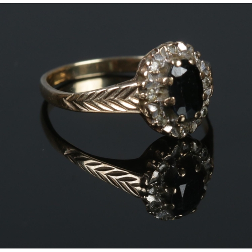 275 - A 9ct Gold and black stone ring, with central stone surrounded by an illusion set border on part che... 