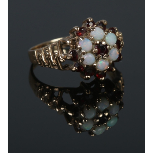 277 - A 9ct Gold Opal and Garnet cluster ring, with waved shoulders. Size M½. Total weight: 3.1g