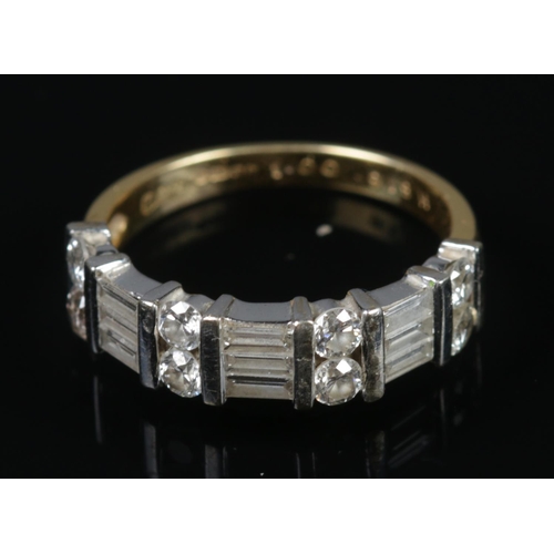 321 - An 18ct gold and diamond ring with 17 stones alternating between brilliant and baguette cut. Stamped... 